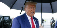 Ex-Präsident Trump mit Regenschirm.