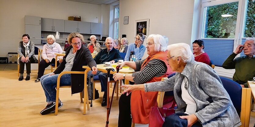 Alte Menschen sitzen in einem Mehrzweckraum