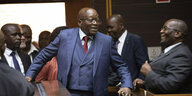 Jacob Zuma läuft im blauen Anzug durchs Bild