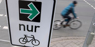 Ein Schild mit einem grünen Pfeil, der nach rechts zeigt, einem Fahrradsymbol und dem Wort "nur"