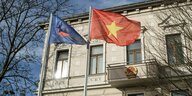 Vietnamesische Flaggen vor einem Gebäude.