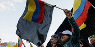 Eine ecuadorianische Fahne weht vor einer schwarzen Fahne