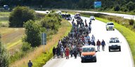 Flüchtlinge laufen in einer Gruppe auf einer dänischen Autobahn