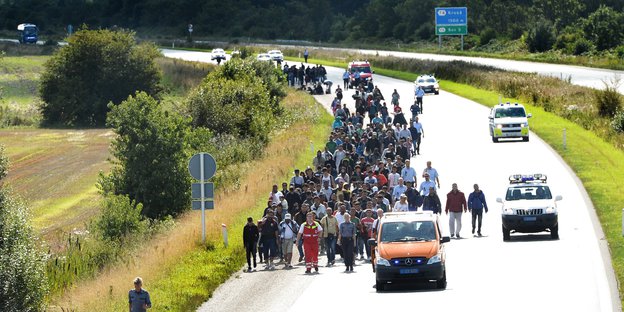 Flüchtlinge laufen in einer Gruppe auf einer dänischen Autobahn