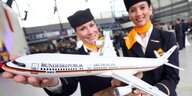 Stewardessen mit Airbusmodell, lächelnd