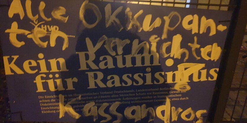 Ein Schild gegen Rassismus ist übermalt mit einer fremdenfeindlichen Parole