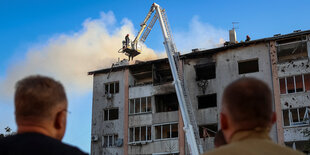 Rettungskräfte im Einsatz an einem brennenden Haus.