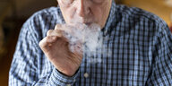 Eine Person raucht einen Joint und es gibt viel Qualm.