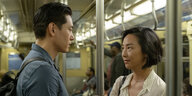 Ein Mann und eine Frau stehen sich in der U-Bahn gegenüber