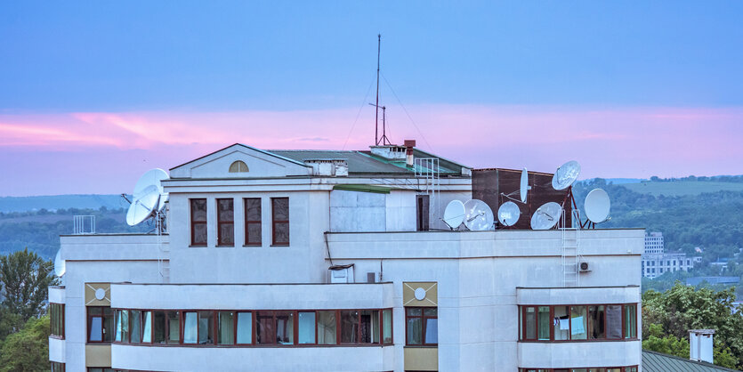 Dach mit vielen Satelliten bei Sonnenuntergang