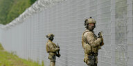 Soldaten stehen vor einem Zaun