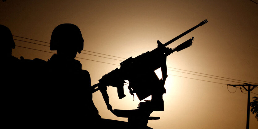 Soldaten mit Waffe als Silhouette.