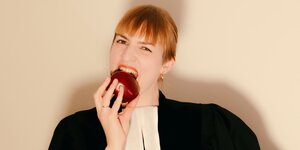 Eine Frau beißt in einen Apfel