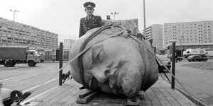 Der Kopf einer Leninstatue liegt auf dem Boden