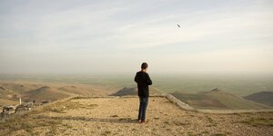 Ein mann steht in einer Landschaft nahe der türkischen Stadt Mardin