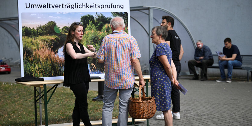 Menschen vor einer zur Infotafel umfunktionierten Bierbank