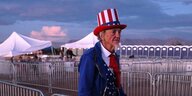Ein mann, der sich als Uncle Sam verkleidet hat, steht neben Veranstaltungszelten