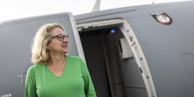 Entwicklungshilfeministerin Schulze vor einem Flugzeug.