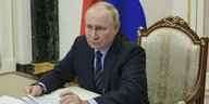 Putin sitzt hinter dem Schreibtsisch