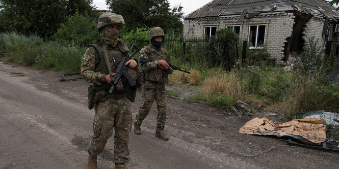 Soldaten auf einer Dorfstraße.