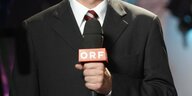 Ein Mann hält ein Mikrofon des ORF in der Hand