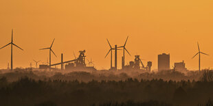 Stahlwerk und Windräder am Horizont