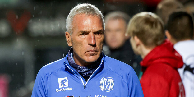 SV Meppens Trainer Ernst Middendorp steht im regen nach einem Spiel auf dem Platz und schaut bedröppelt: