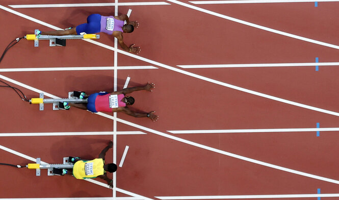 Drei leichtathletische Sprinter vor dem Start, von oben fotografiert