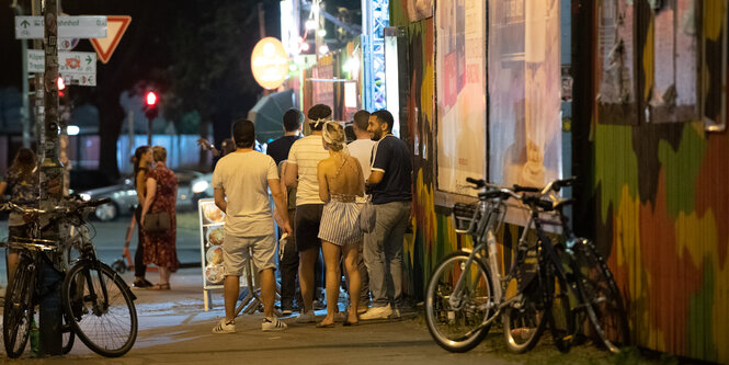 Menschen stehen in einer Schlange vor dem Club Yaam in Friedrichshain