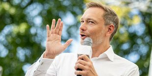 Finanzminister Lindner mit Mikrofon in der Hand.