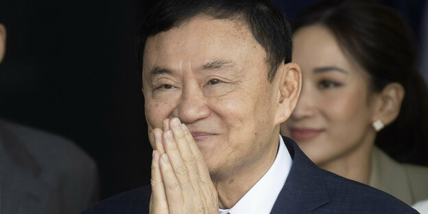 Thailands Ex-Premier Thaksin Shinawatra begrüßt am Dienstag seine Anhänger bei der Rückkehr aus dem Exil mit gefalteten Händen