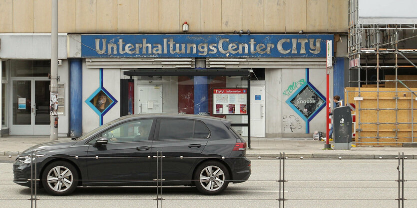 Ein Auto fährt an einem Gebäude vorbei, an dem "UnterhaltungsCenterCity" steht