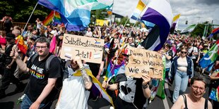 Menschen demonstrieren beim CSD in Berlin für mehr Selbstbestimmung und halten Plakate hoch mit der Aufschrift "Selbstbestimmung jetzt"