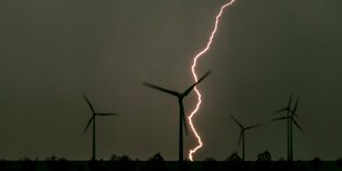 Ein Blitz erhellt fünf Windräder