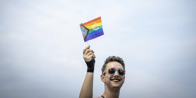 Eine Person mit einem Regenbogenfähnchen.