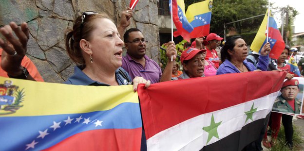 Menschen mit syrischer und venezolanischer Flagge vor der syrischen Botschaft in Caracas