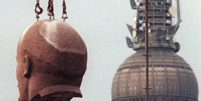 Lenin schwebt durch die Straßen Berlins, daneben der Fernsehturm