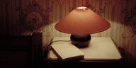 Buch unter einer Nachttischlampe.