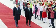 Chinas Präsdident Xi geht mit dem brasilianischen Präsidenten Lula in Peking an einer Gruppe jubelnder SchülerInnen vorbei