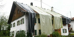 Nach dem Unwetter ist das Dach eines Wohnhauses mit Planen provisorisch abgedeckt.