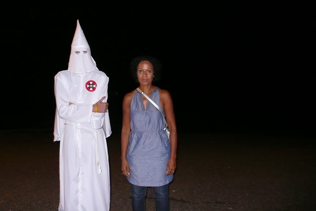 Eine Frau steht neben einem Mitglied aus dem Ku Klux Klan.
