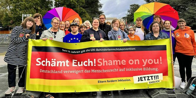 Demonstrierende Eltern mit Kindern halten ein Plakat: Schämt euch ! Shame on you !