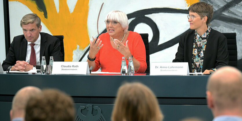 Auf dem Podium sitzen Uwe Neumärker, Direktor der Stiftung Denkmal fürdie ermordeten Juden Europas, Claudia Roth und Anna Lührmann