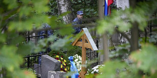 Das Grab von Jewgeni Prigoschin in St. Petersburg, durch das Laub sind Soldaten zu erkennen