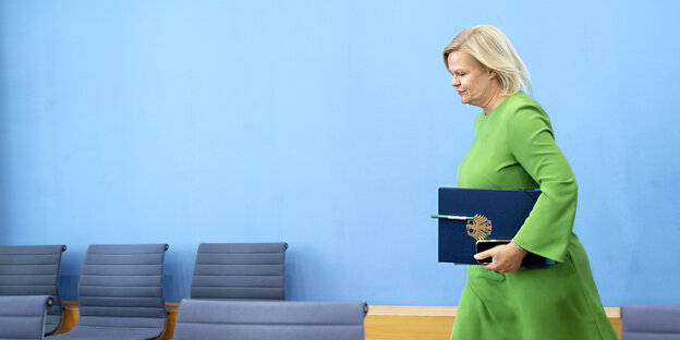 Bundesinneministerin Nancy Faeser von der SPD bei einer Pressekonferenz im grünen Kleid