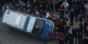 Nazihooligans werfen ein Polizeiauto um