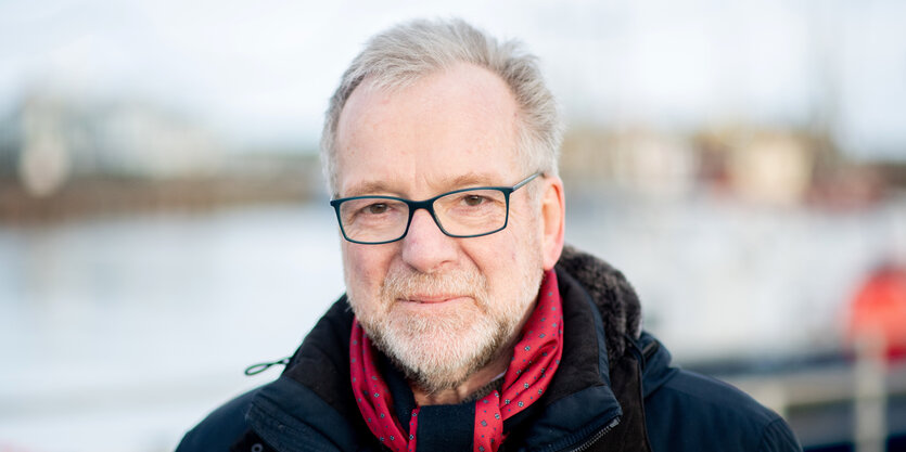 Johann Kühme steht vor einem Steg der Wasserschutzpolizei im Hafen.