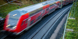 Ein Nahverkehrszug fährt über eine neu gebaute Bahnstrecke