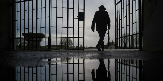 Ein Mann läuft durch das Tor des Konzentrationslagers Sachsenhausen