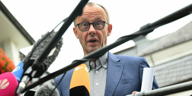 Friedrich Merz hinter Mikrofonen